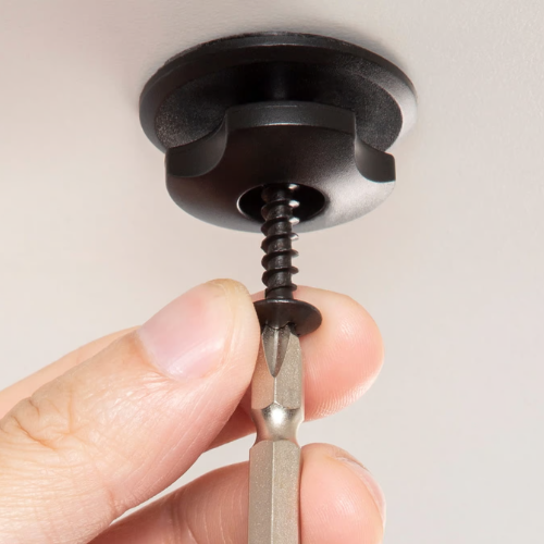 Screwdriver installing a ceiling mount or light fixture in a ceiling.